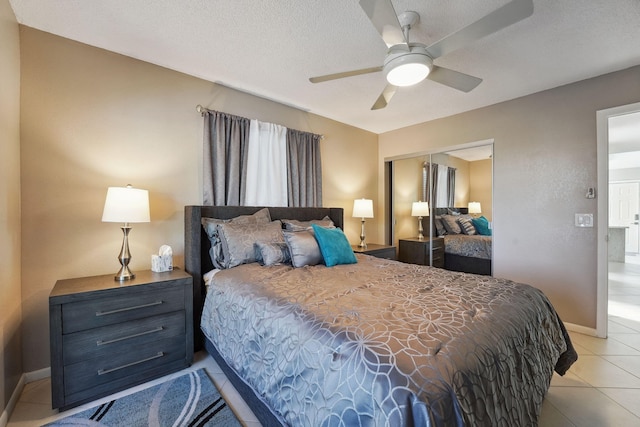 bedroom with light tile patterned floors, a textured ceiling, a closet, and ceiling fan