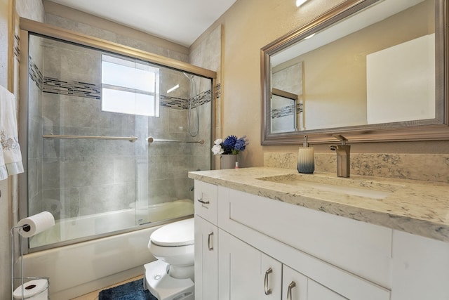 full bathroom featuring vanity, toilet, and combined bath / shower with glass door