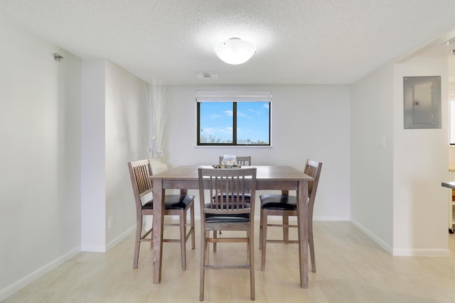 dining space featuring a textured ceiling and electric panel