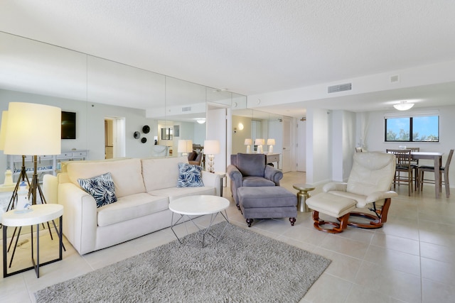 tiled living room featuring a textured ceiling