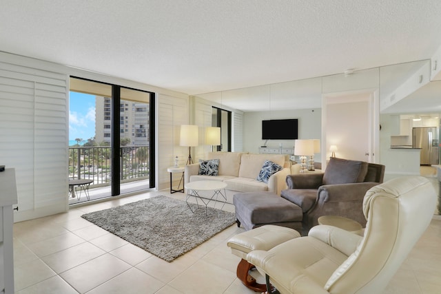 tiled living room featuring floor to ceiling windows and a textured ceiling