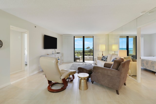 tiled living room with a textured ceiling and expansive windows