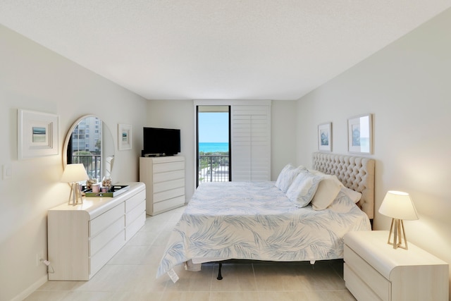 bedroom with light tile patterned floors and access to outside