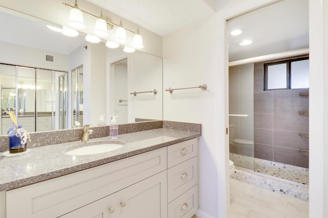 bathroom featuring vanity, toilet, and a tile shower