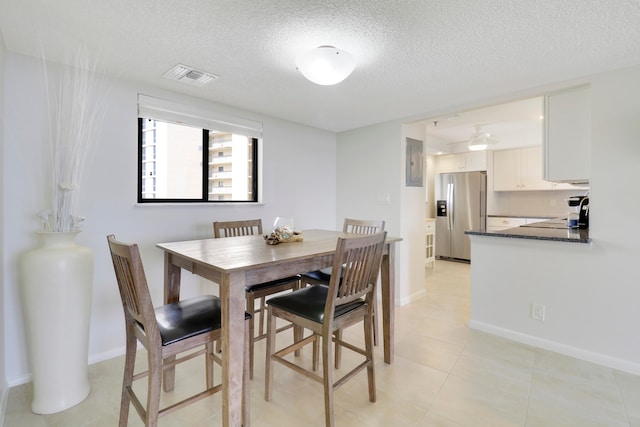 dining area featuring a textured ceiling and light tile patterned flooring