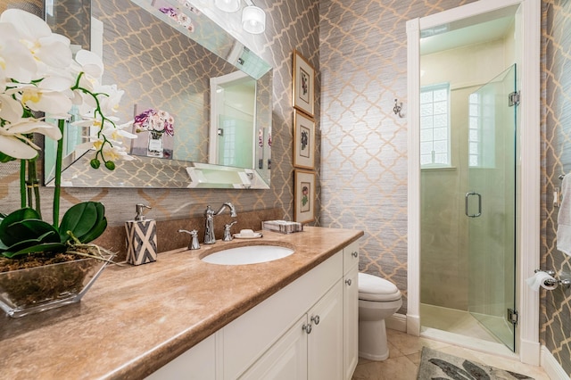 bathroom with tile patterned flooring, vanity, toilet, and walk in shower