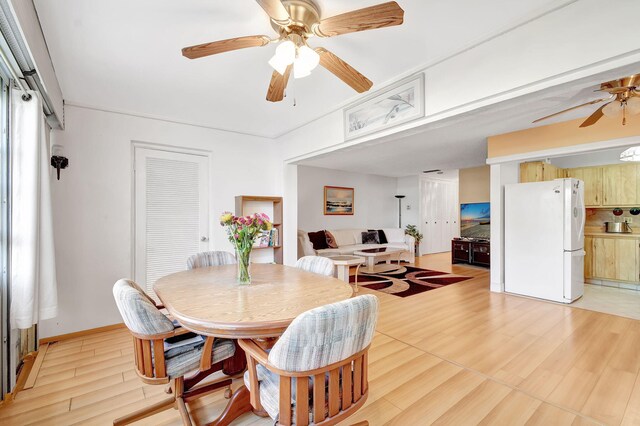 kitchen with light brown cabinets, white appliances, tasteful backsplash, and light hardwood / wood-style flooring