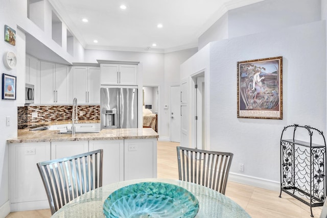 dining room featuring light hardwood / wood-style floors, crown molding, and sink