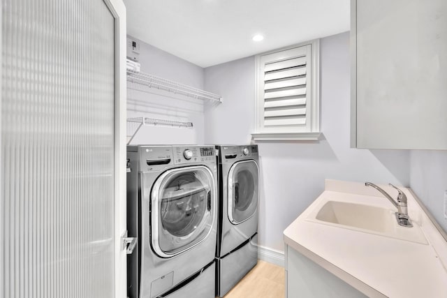 clothes washing area with washer and clothes dryer and sink