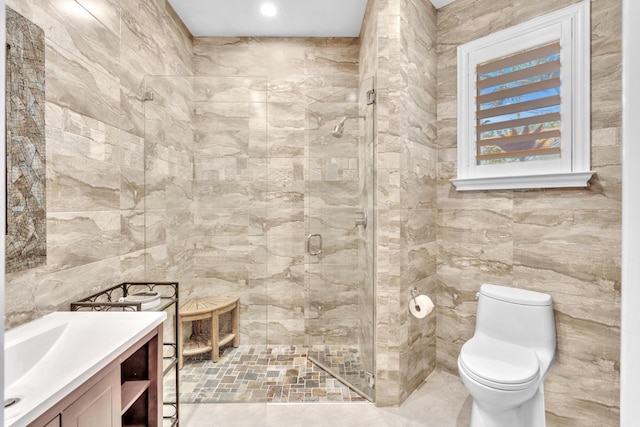 bathroom featuring vanity, a shower with shower door, tile walls, and toilet