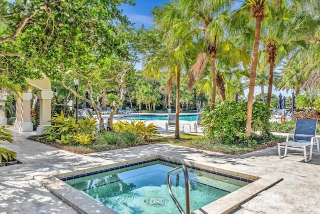 view of pool featuring a hot tub and a patio area