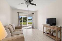 living room featuring ceiling fan and light hardwood / wood-style flooring