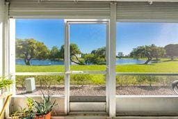 unfurnished sunroom featuring a water view