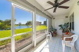 sunroom / solarium featuring a water view and ceiling fan