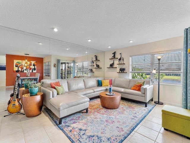 living room featuring light tile patterned floors, a chandelier, and a textured ceiling