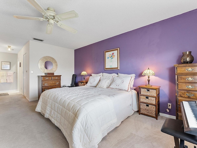 carpeted bedroom featuring ceiling fan, a textured ceiling, and a closet