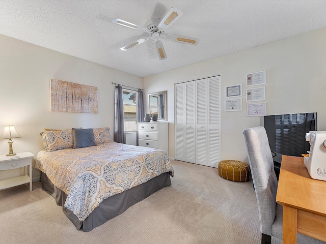 carpeted bedroom with a textured ceiling, a closet, and ceiling fan