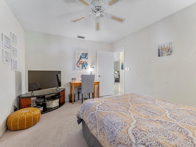 bedroom with a textured ceiling, light colored carpet, and ceiling fan