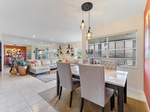 dining room with light tile patterned floors, a textured ceiling, and a notable chandelier