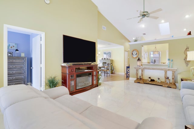 living room with ceiling fan, light tile patterned floors, high vaulted ceiling, and a skylight