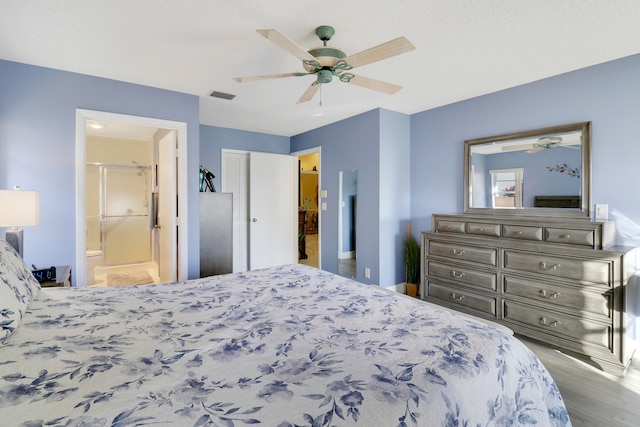 bedroom featuring a closet, connected bathroom, hardwood / wood-style flooring, and ceiling fan