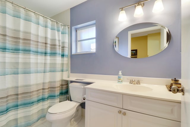 bathroom with tile patterned floors, vanity, toilet, and walk in shower