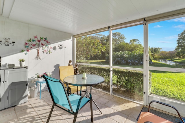 sunroom with plenty of natural light and a water view