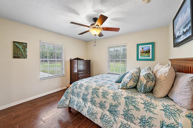 bedroom featuring ceiling fan, dark hardwood / wood-style flooring, and a textured ceiling