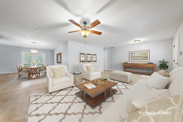 living area featuring visible vents, baseboards, ceiling fan, light tile patterned flooring, and a textured ceiling