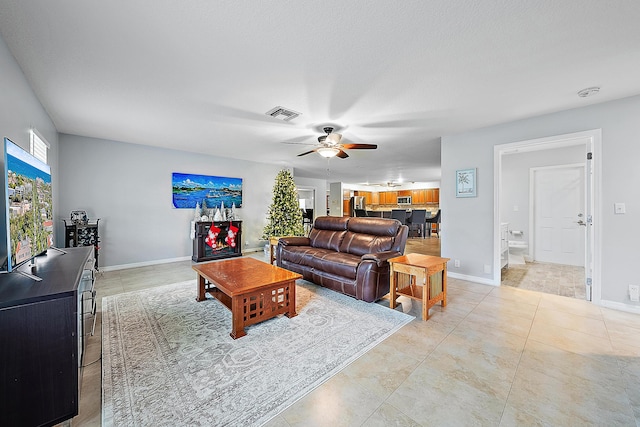 living room with ceiling fan and light tile patterned floors