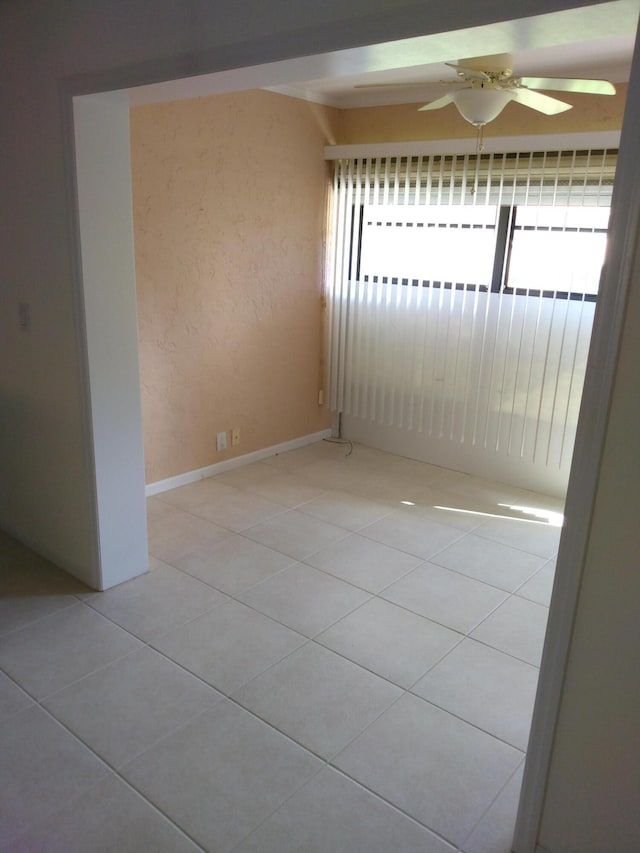 tiled empty room featuring ceiling fan