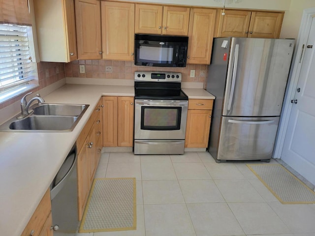 kitchen featuring sink, stainless steel appliances, tasteful backsplash, and light tile patterned floors