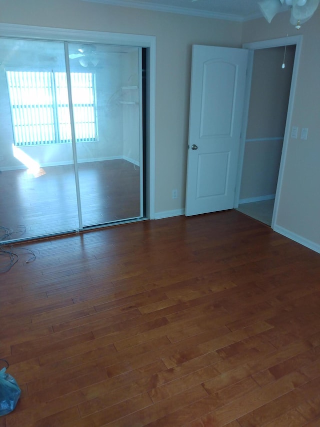 unfurnished bedroom featuring a closet, ceiling fan, and dark wood-type flooring