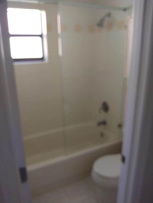 bathroom featuring toilet, tile patterned flooring, and shower / bath combination