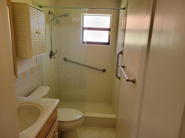 bathroom with toilet, tile patterned flooring, tile walls, and tiled shower