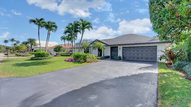 single story home featuring a front yard and a garage