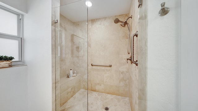 bathroom with tiled shower and plenty of natural light