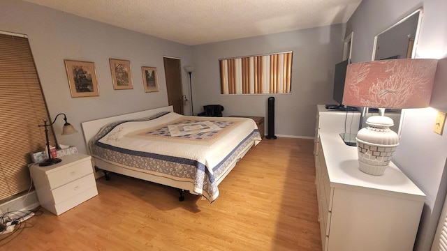 bedroom with light hardwood / wood-style floors and a textured ceiling