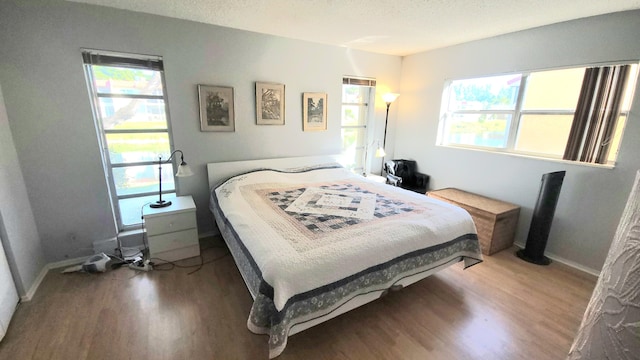 bedroom with hardwood / wood-style floors and a textured ceiling