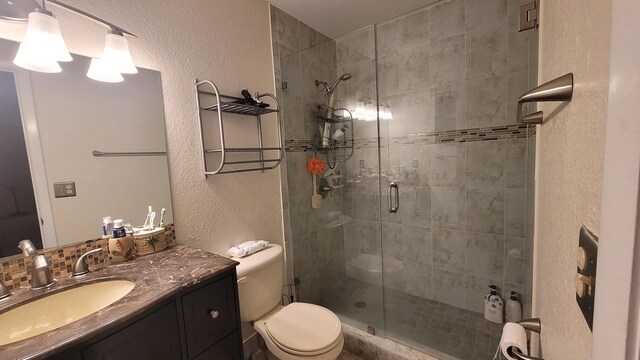 bathroom with vanity, toilet, and a shower with shower door