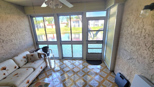 interior space with ceiling fan and a water view