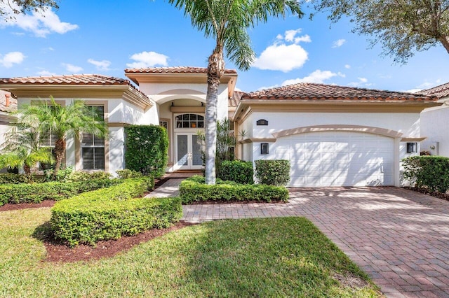 mediterranean / spanish-style house featuring french doors and a garage