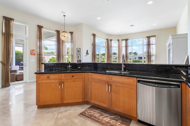 kitchen featuring dishwasher, plenty of natural light, dark stone counters, and sink