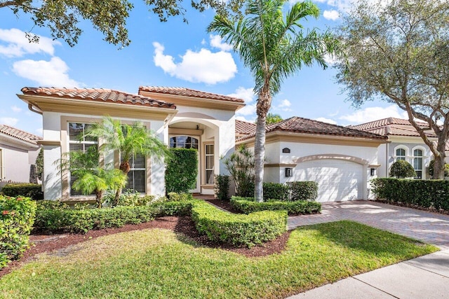 mediterranean / spanish-style house featuring a garage and a front lawn