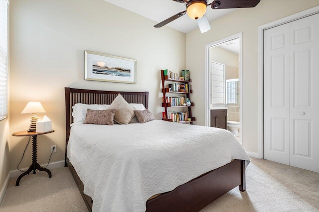 carpeted bedroom with connected bathroom, ceiling fan, and a closet