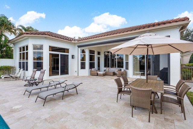 back of property with outdoor lounge area and a patio