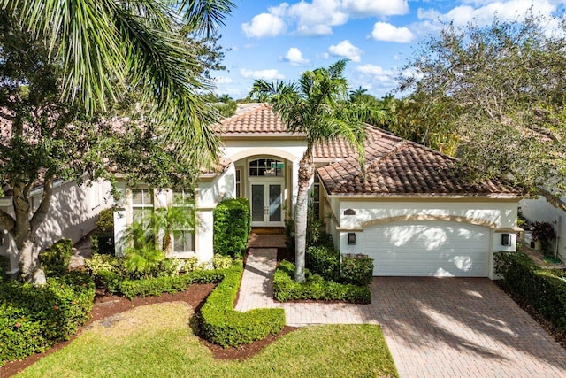 mediterranean / spanish-style home featuring french doors and a garage