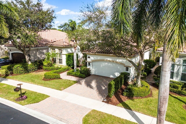 mediterranean / spanish-style house with a garage and a front lawn