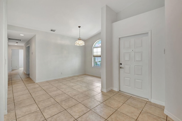 entrance foyer with light tile patterned floors and a chandelier