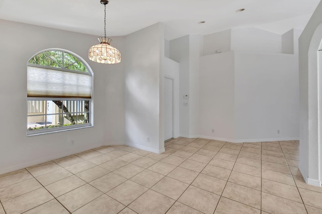 spare room featuring light tile patterned flooring and an inviting chandelier